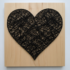 String art heart with black yarn on natural wood board