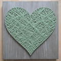 String art heart with sage yarn on cool weathered grey wooden board