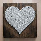 String art heart with white twine on rustic wooden board